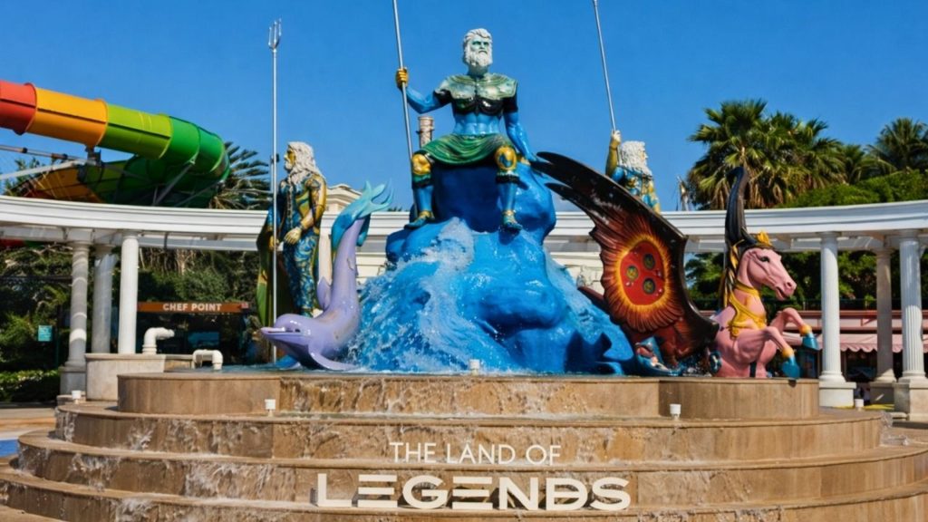 Poseidon statue fountain at the entrance of Land of Legends theme park with waterslides behind