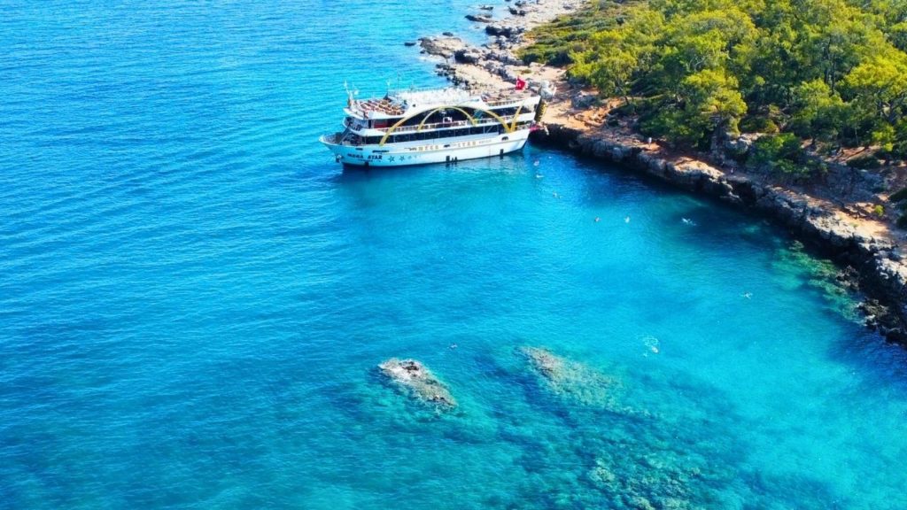 Mega Star boat anchored in crystal-clear turquoise bay along Antalya coastline