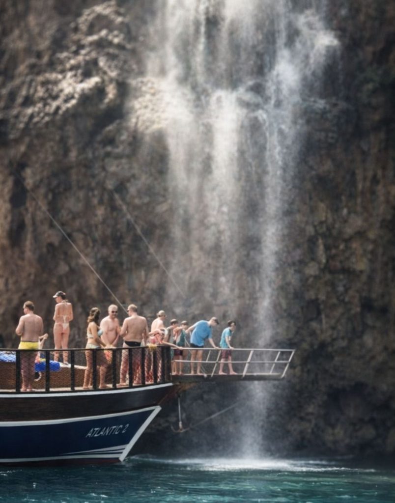 Tour boat right under the waterfall during Antalya Waterfall Boat Trip