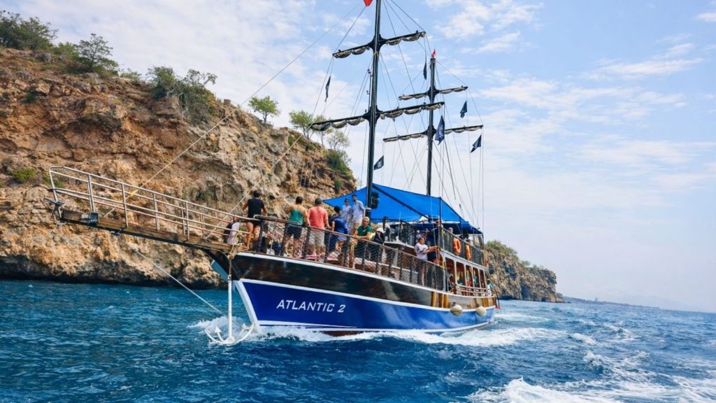 Tour boat cruising along rocky Antalya coastline during Waterfall Boat Trip