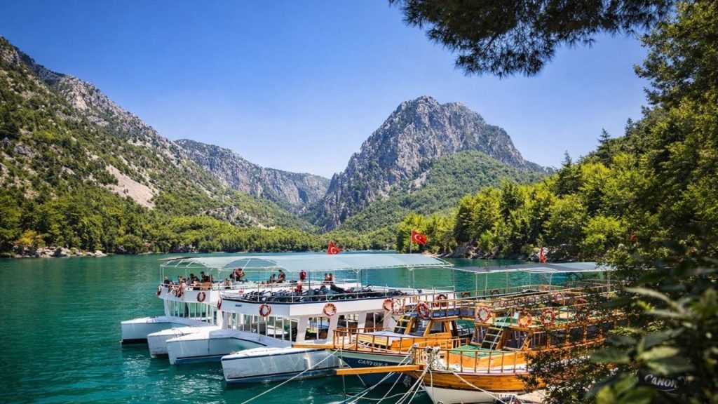 Tour boats docked at Green Canyon harbour with Taurus Mountains in background