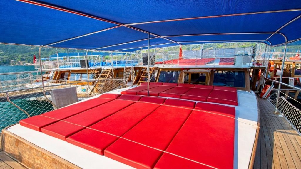 belek suluada boat tour deck with red sunbed cushions and blue canopy