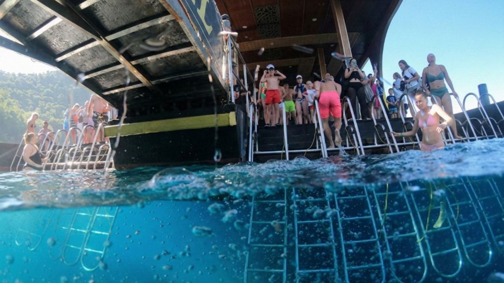 Visitors swimming in turquoise water during Big Kral boat trip swimming break in Alanya