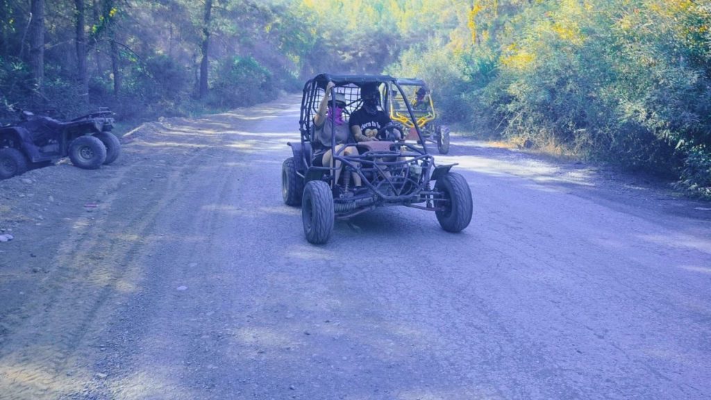 Buggy driving through pine forest dirt road on Alanya buggy safari tour