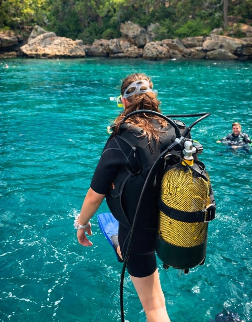 Diver ready to jump into turquoise water from diving boat in Alanya