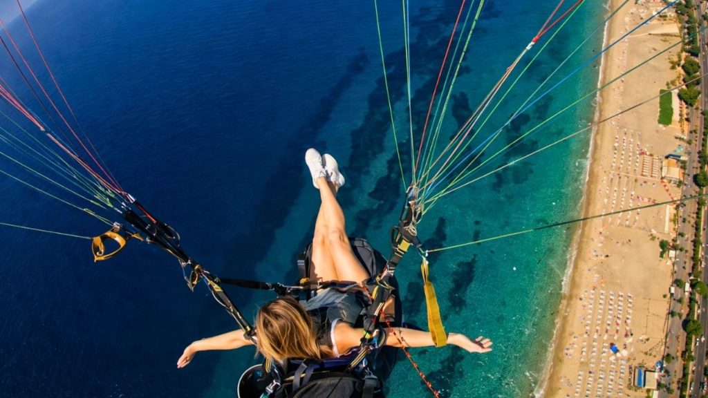 Tandem paragliding flight high above turquoise sea and Cleopatra Beach in Alanya