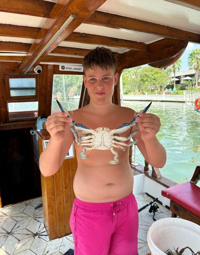 Boy holding a crab caught on the Alanya fishing tour boat