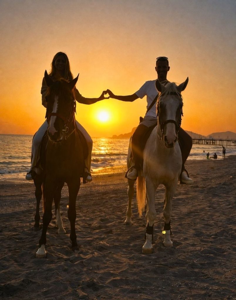 Couple on horses making heart shape at sunset on Alanya beach