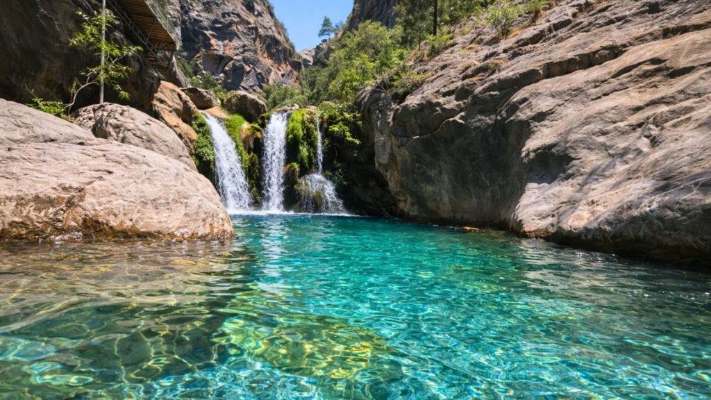 Crystal clear turquoise natural pool with waterfall inside Sapadere Canyon