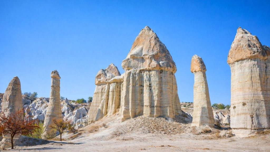Tall fairy chimney rock formations in Love Valley Cappadocia under blue sky