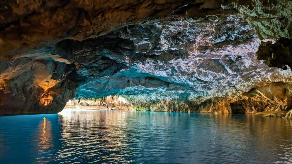 Blue illuminated underground cave with turquoise water inside Altinbesik Cave complex Alanya