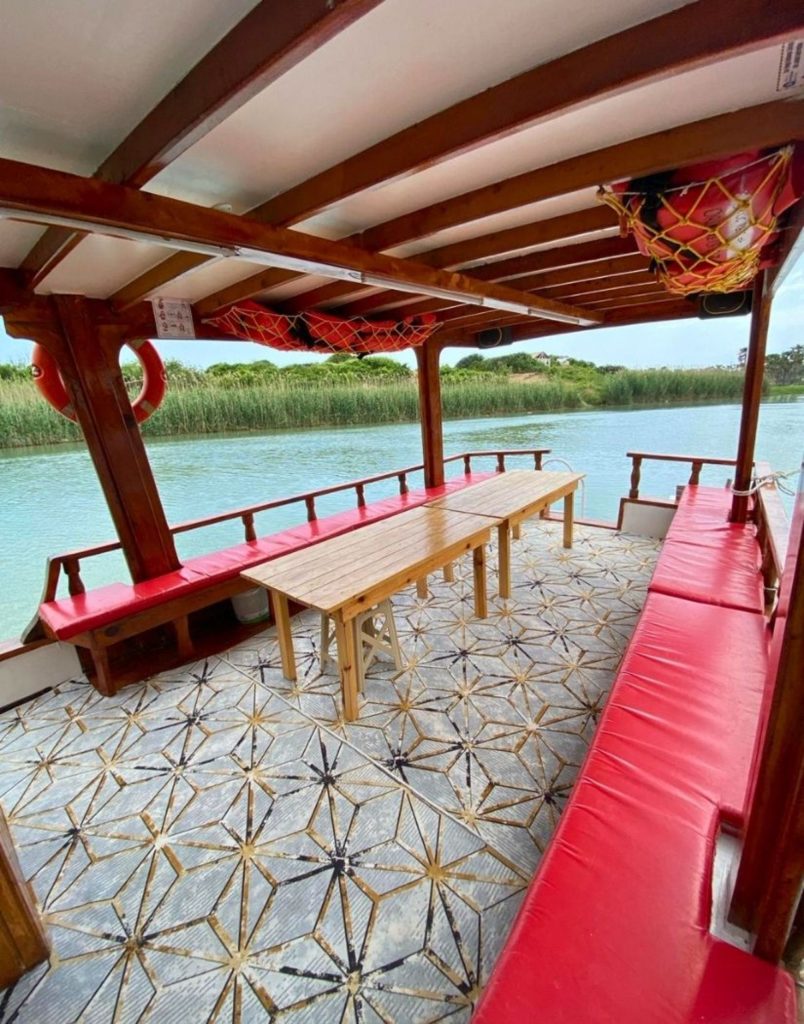 inside the wooden fishing boat with red cushions near manavgat river before sea fishing in side
