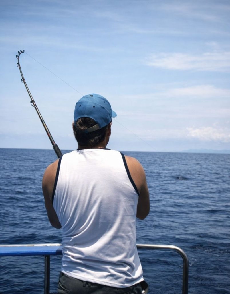 fishing rod cast over open calm blue mediterranean during sea fishing in side tour