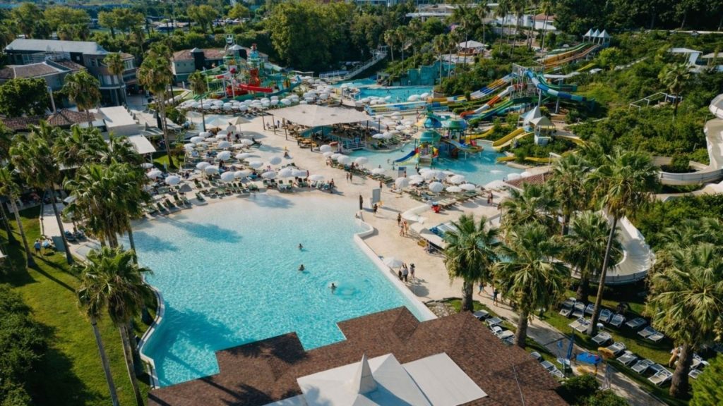 water hill aquapark aerial view with large pool sun umbrellas palm trees and water slides