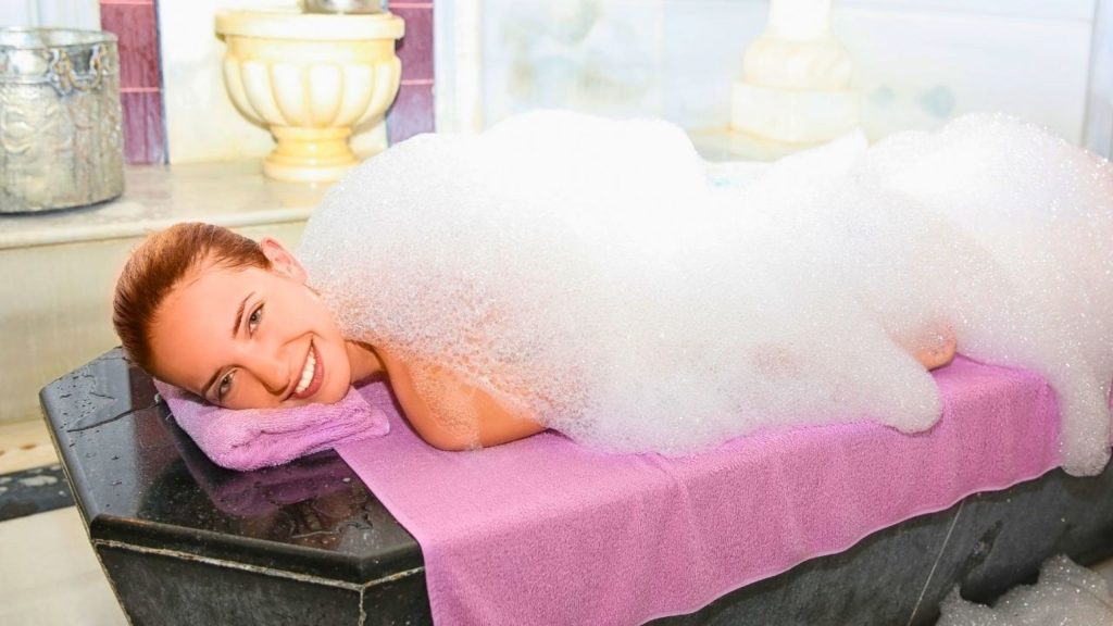 Traditional foam massage on heated marble stone at Antalya Turkish bath