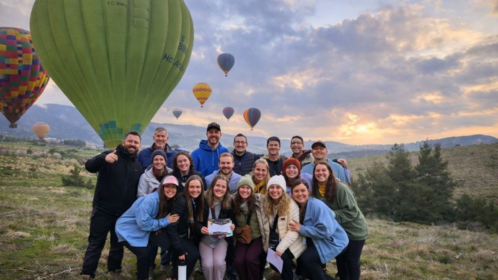 Group photo with hot air balloons at sunrise in Pamukkale during Antalya balloon and Pamukkale tour
