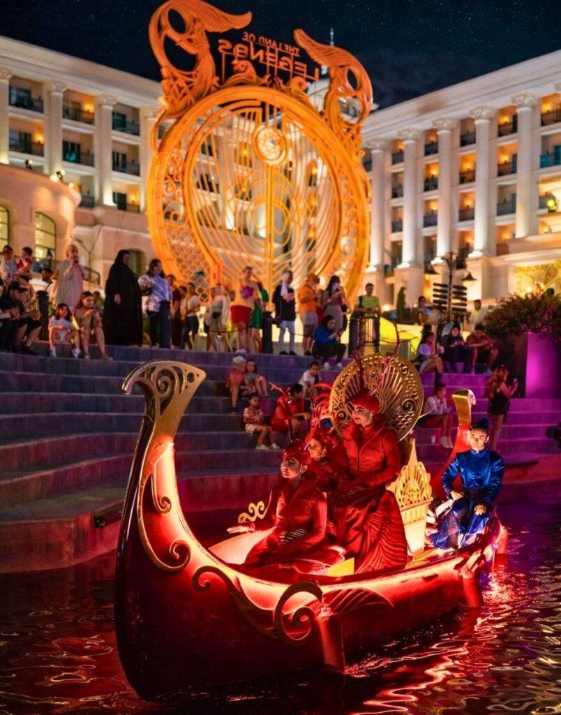 Royal themed illuminated boat floating on water canal during Land of Legends Night Show Antalya