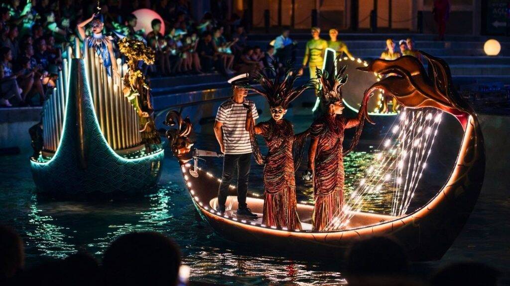 Illuminated fantasy boats with costumed performers on water at Land of Legends Night Show Antalya