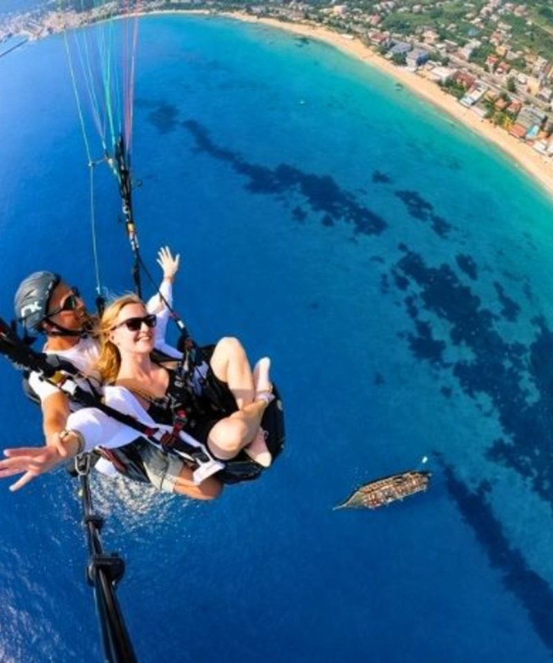 Tandem paragliding flight over Antalya coastline and turquoise Mediterranean sea