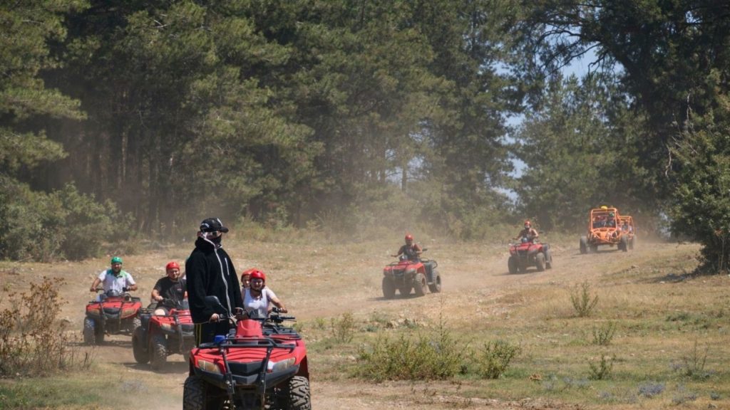 Quad bike and buggy convoy riding through dusty forest trail on Antalya safari tour