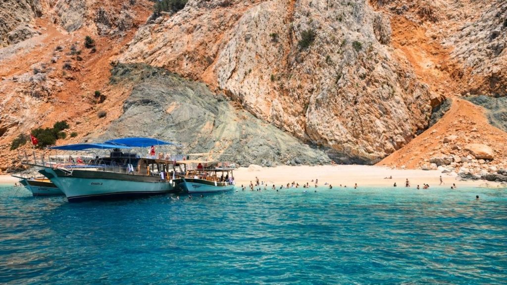 belek suluada boat tour boats anchored at the island beach with turquoise water and rocky cliffs