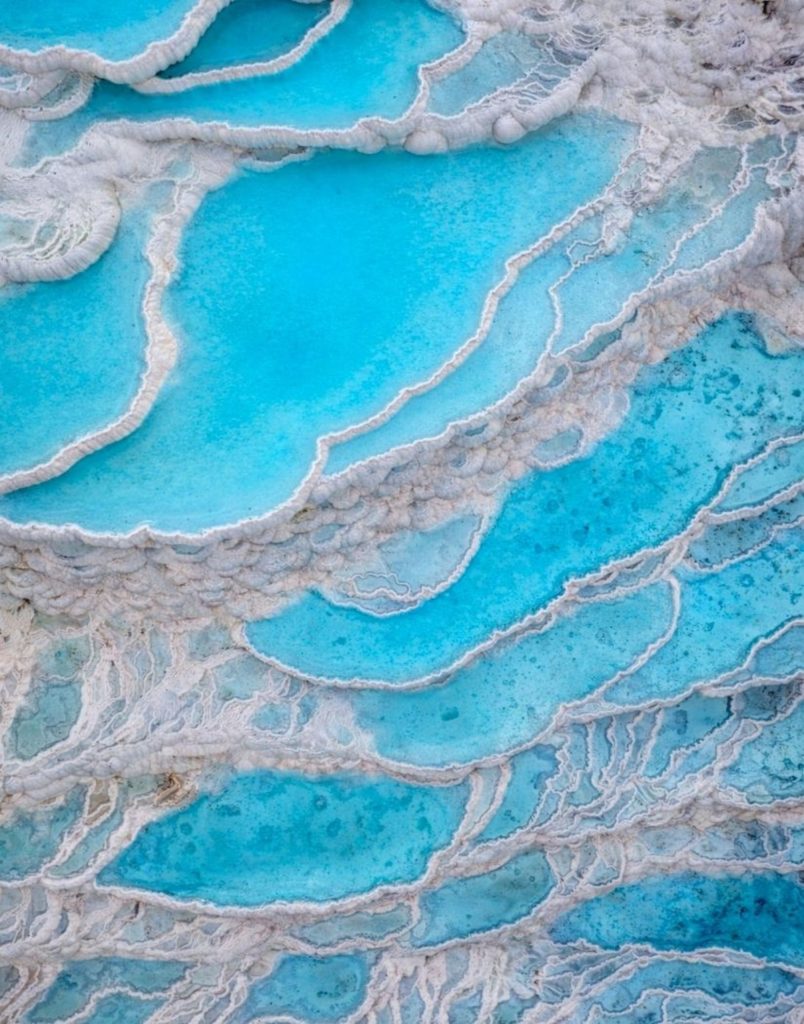 Close-up of turquoise thermal pools flowing through white travertine terraces at Pamukkale