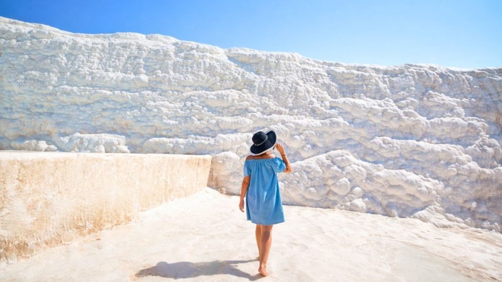 Woman walking on Pamukkale white travertines during a guided tour from Antalya