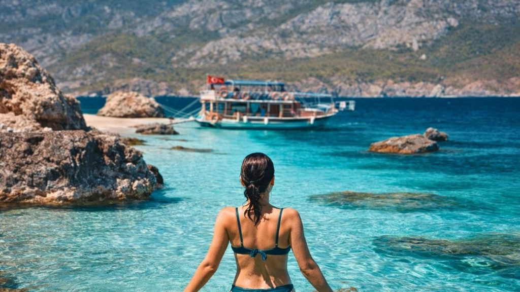 Crystal clear turquoise water with tour boat at Suluada Island during boat trip from Antalya