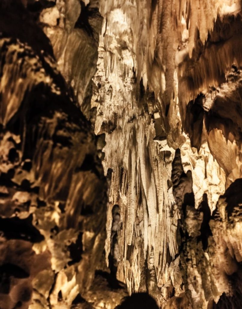 side altinbesik cave tour stalactite and stalagmite formations with warm lighting