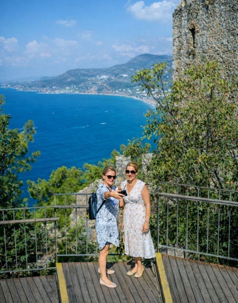Two visitors taking selfie at Alanya Castle with Mediterranean Sea view