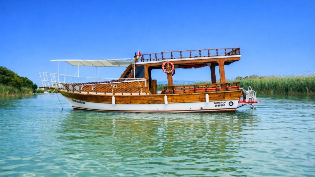 Traditional wooden fishing boat on calm green water on Alanya fishing tour