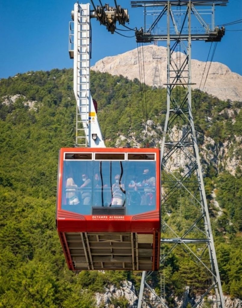 Red Olympos Cable Car cabin with Tahtali Mountain behind in Antalya