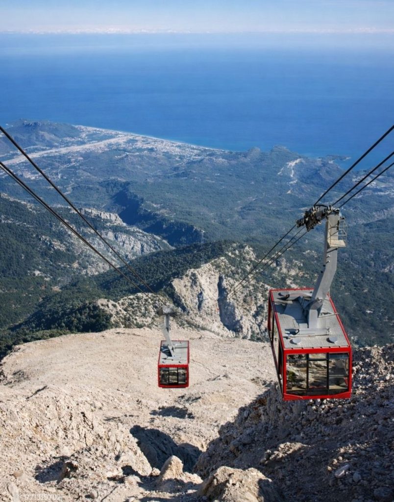 Two Olympos Cable Car cabins from Tahtali Mountain summit with Antalya coast far below