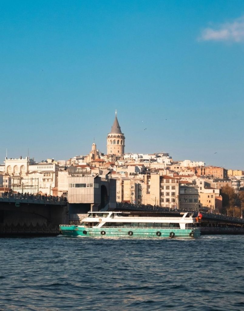 Galata Tower and bridge with ferry boat cruising on Golden Horn Istanbul