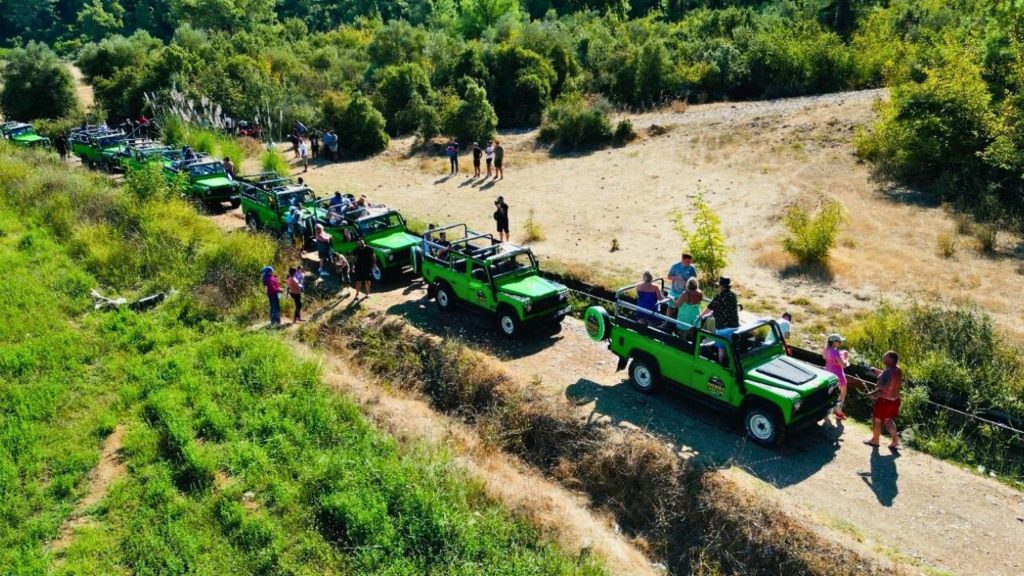 Aerial view of jeep safari convoy stopping in lush green Antalya countryside