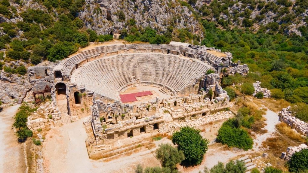 Visitor in front of Myra Lycian rock tombs during Demre Myra Kekova Tour from Antalya