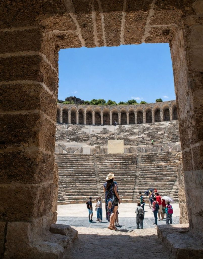 Visitors entering Aspendos Theatre through the original Roman stone doorway