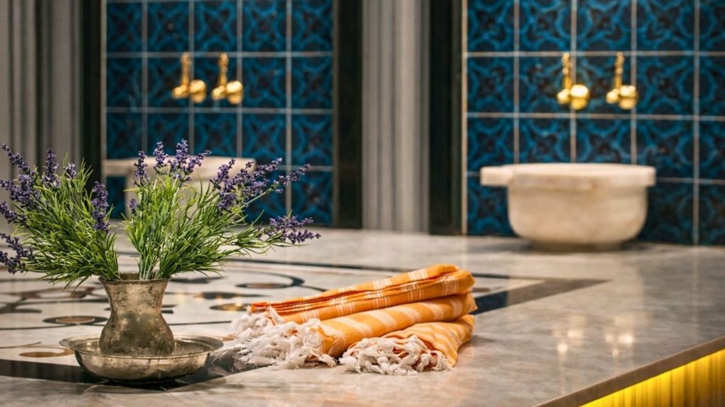 Traditional Turkish hammam interior with blue ceramic tiles golden taps marble basin and pestemal