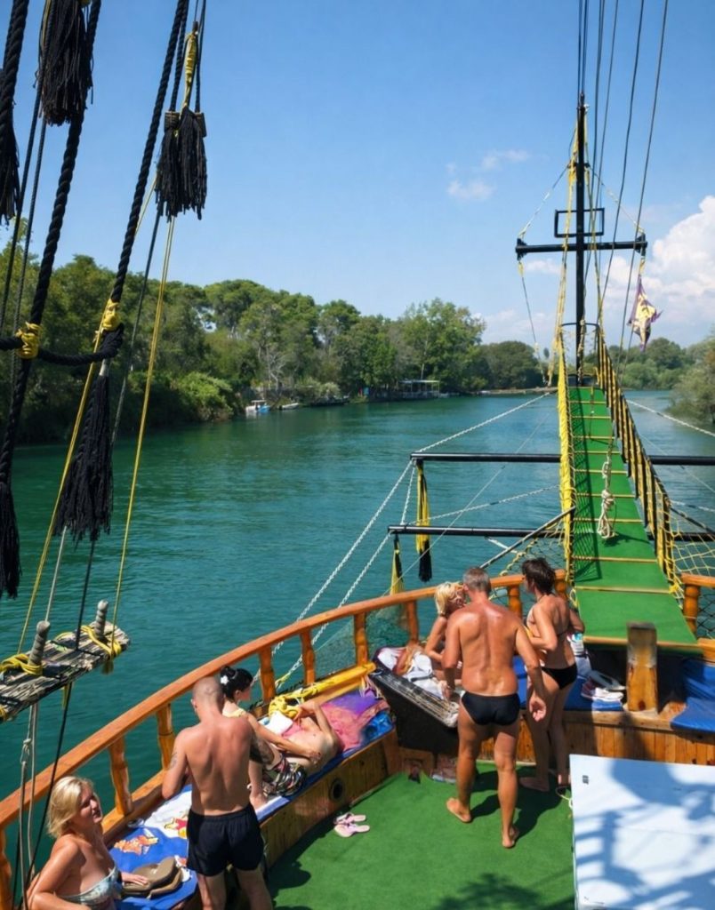 Tour boat deck view on Manavgat River with green banks and blue sky