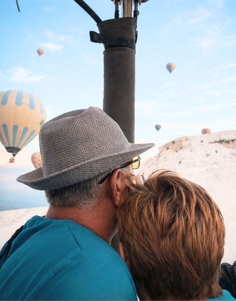 Couple enjoying hot air balloon ride together over Pamukkale white travertines