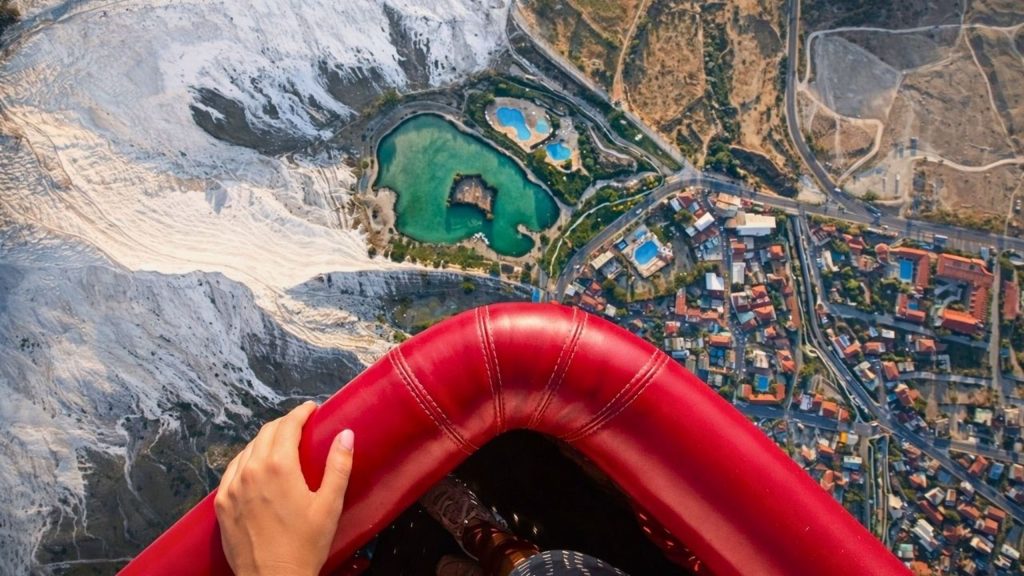 Aerial view from hot air balloon basket looking down at Pamukkale travertines and thermal pools