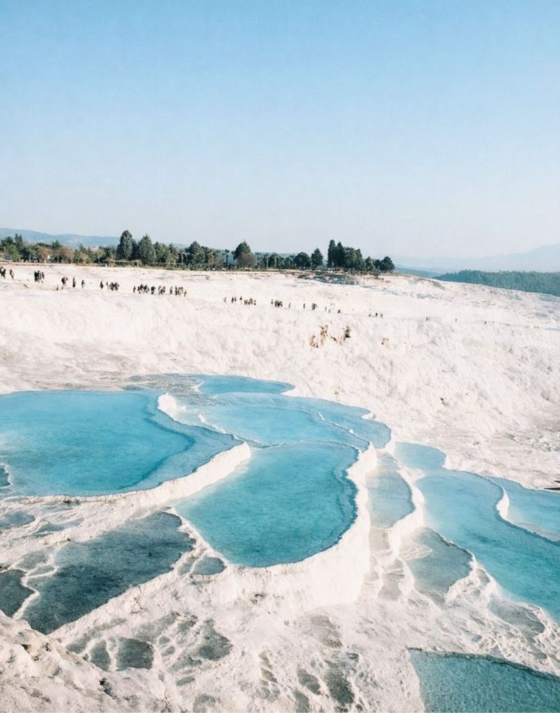 Pamukkale white travertine pools with bright turquoise thermal water wide landscape view