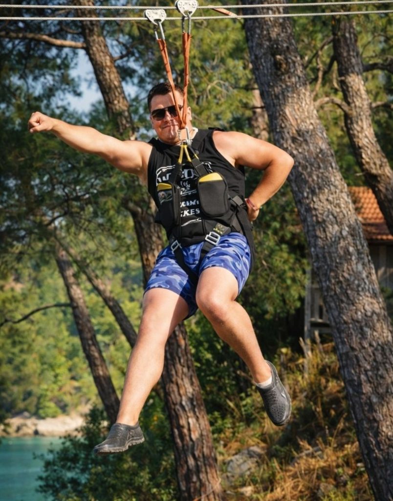 Antalya zipline rider posing over turquoise river with pine forest on combo adventure tour
