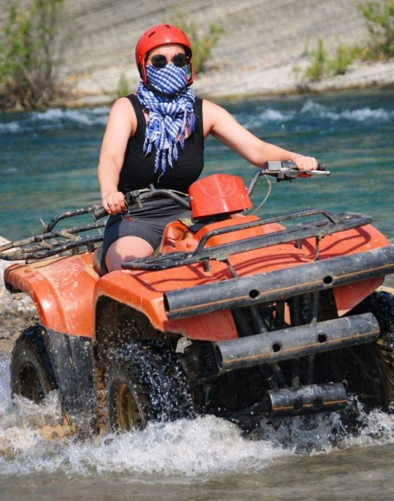 Antalya quad safari rider crossing river with water splash on off-road adventure tour