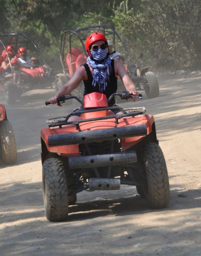 Quad bike racing on dusty trail with dust cloud during Antalya Quad Safari adventure