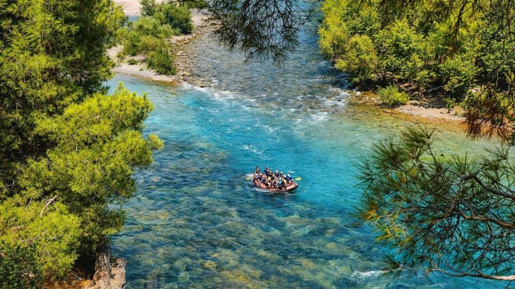Aerial view of rafting on turquoise Koprulu Canyon river surrounded by green pine forest in Antalya