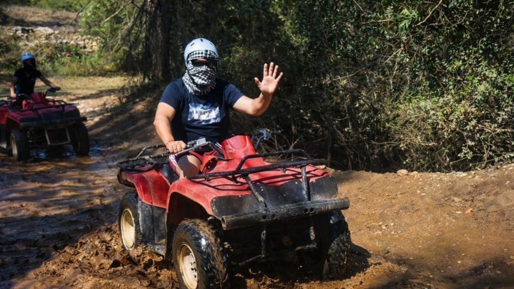 Quad bike riding through muddy forest trail during Antalya Quad Safari and Rafting Tour