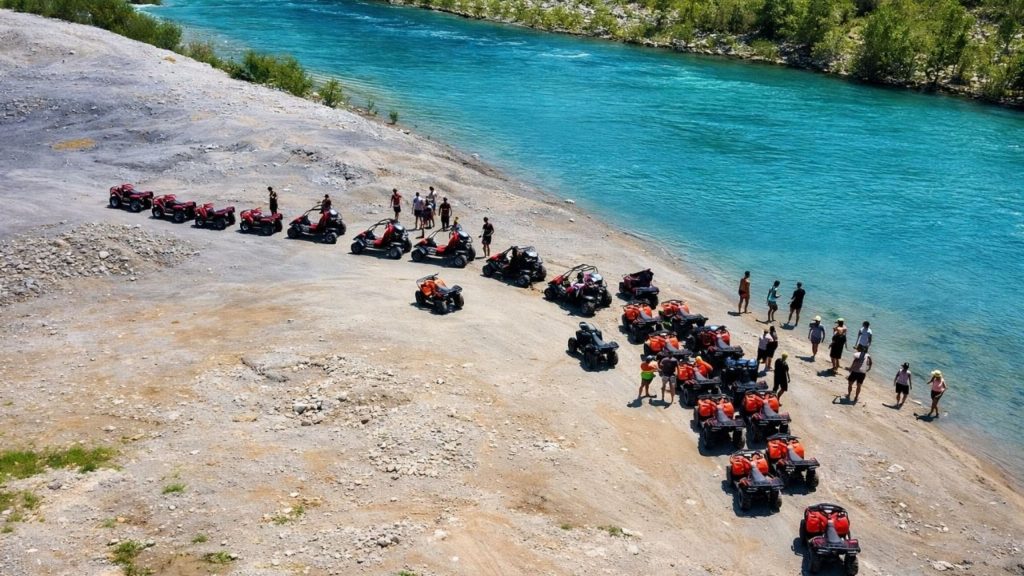 Aerial view of quad bikes parked by turquoise Koprulu Canyon river during Antalya Quad Safari and Rafting Tour