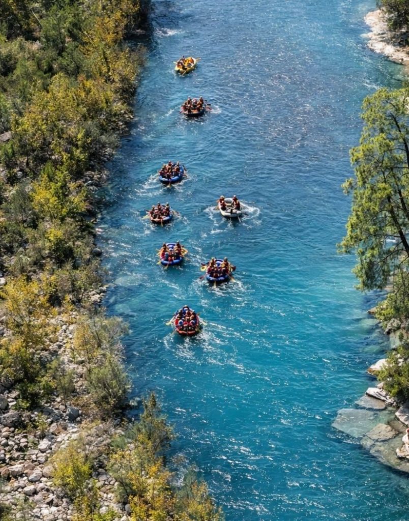Aerial view of Koprulu Canyon with multiple rafting boats on turquoise river surrounded by pine forest