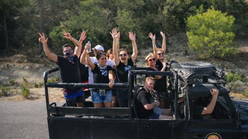 Antalya jeep safari group with hands up on mountain road through Taurus Mountains